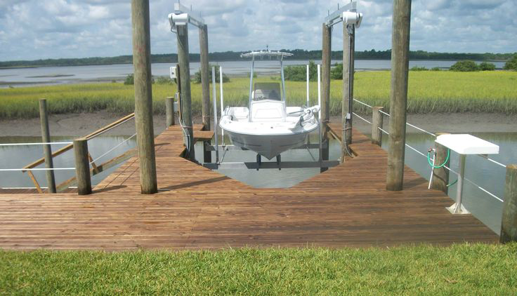 Front view of the wooden deck and dock with white boat on the florida