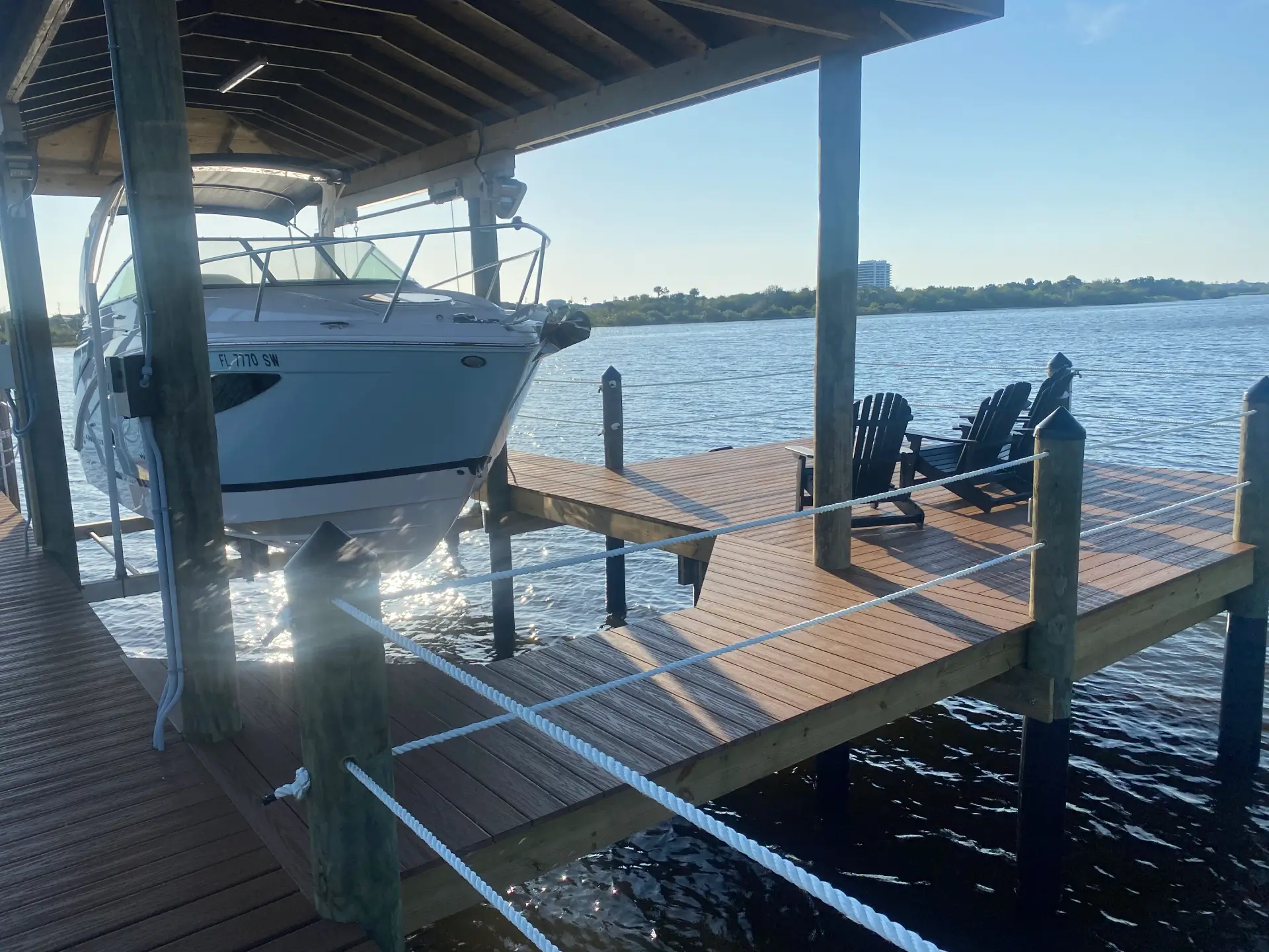Hardwood deck with dock and chairs on it