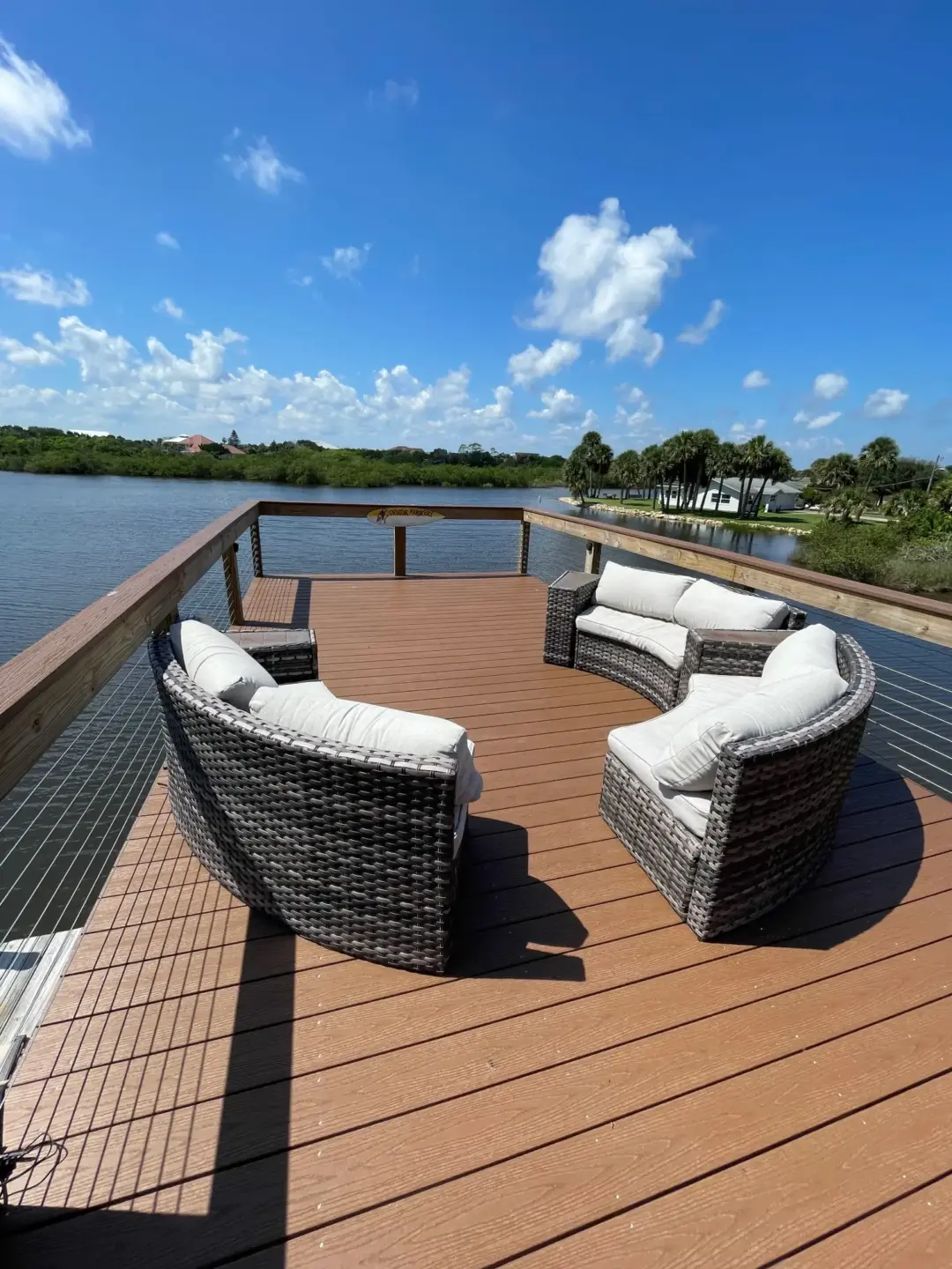 Pvc deck with wire railing and couch featuring clear sky view