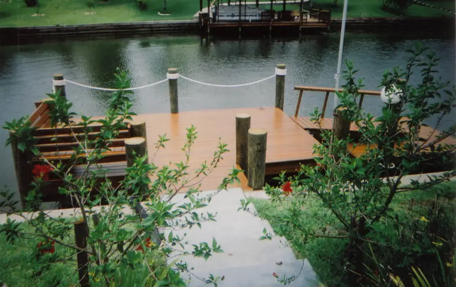 Residential dock featuring plants and river on the background